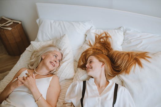 pexels photo 5705059 5705059 1 A loving moment between a grandmother and her granddaughter lying on a bed, smiling warmly.